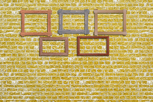 Vintage photo frames on golden brick wall for interior or background.