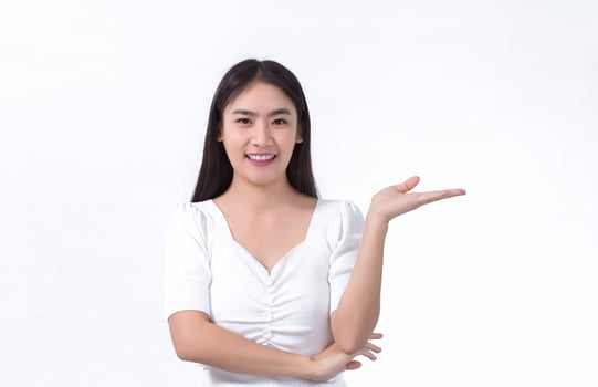 Asian beautiful woman with black long hair wearing a white shirt and pretty smiling is present product on white background. photo