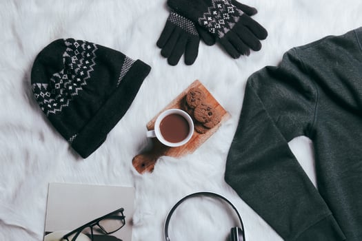 Creative flat lay of sweater, beanie, winter gloves for winter season background photo