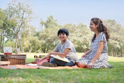 A half-Thai Indian boy and a half-Thai-European girl friend learning outside of school in the park photo