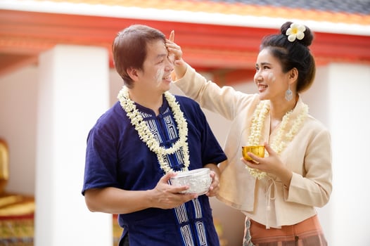Thai men and women in Thai costumes use water-soluble powder to paint their cheeks with joy in celebrating the Songkran water festival photo