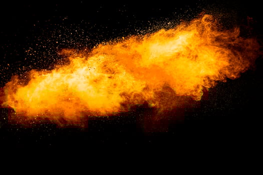 Orange color powder explosion on black background. photo