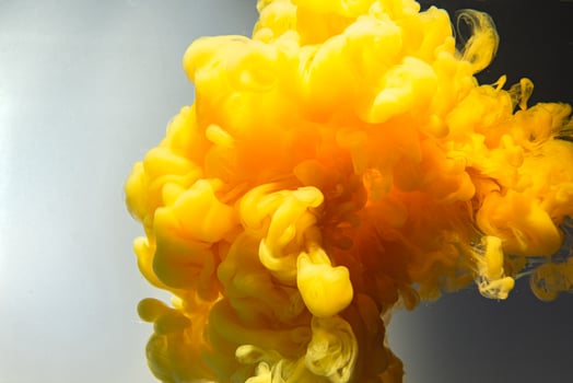 Color drops in water.Yellow ink drop swirling on background. Cloud of acrylic ink. photo