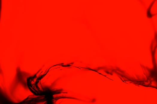 Abstract black alcrylic ink in water on red background.Fantasy chaotic colorful fractal pattern. photo