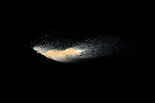 Dry river sand explosion.Brown color sand splash against black background. photo