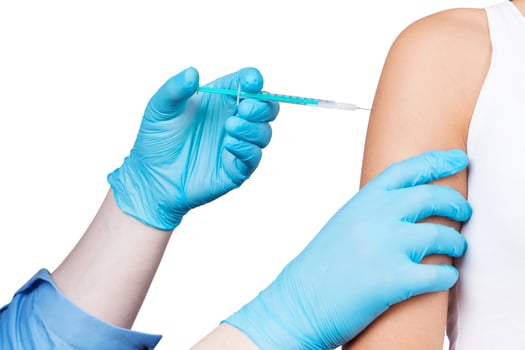 Doctor gives a syringe with vaccine to patient at clinic. photo