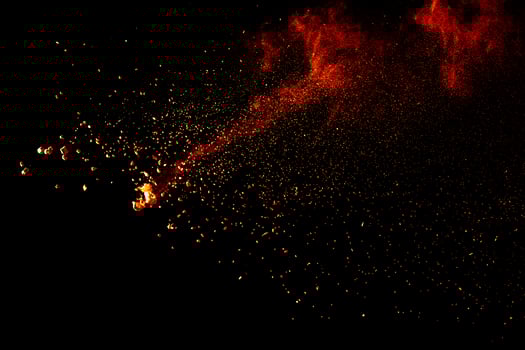 Red orange color powder explosion cloud isolated on black background. photo