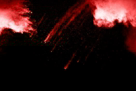Red powder explosion on black background. Freeze motion of Red dust particles splash. photo