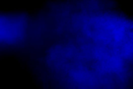 Abstract red blue dust explosion on  black background.Freeze motion of red blue powder splash.Painted Holi in festival photo