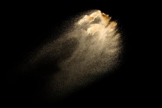 Dry river sand explosion isolated on black background. Abstract sand cloud.Brown colored sand splash against dark background. photo