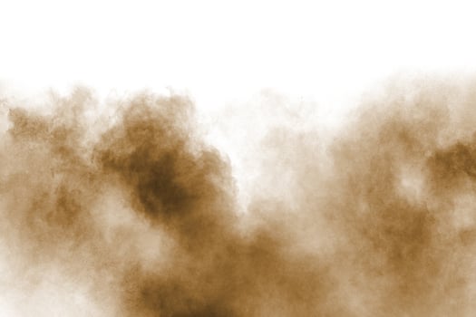Freeze motion of brown dust explosion. Stopping the movement of brown powder. Explosive brown powder on white background. photo