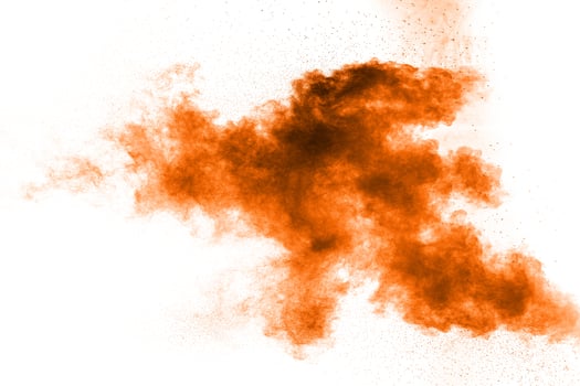 Abstract orange dust explosion on white background. Abstract orange powder splattered on white background. photo