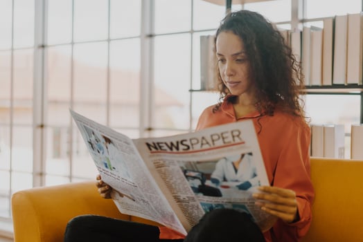 Latin America woman reading newspaper on sofa photo