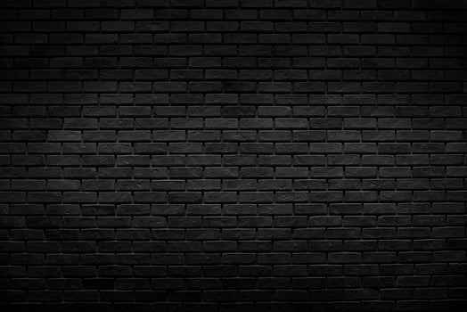 The old vintage black brick wall background with lighting decoration and dark tone style for background design concept photo