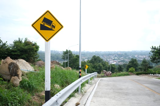 Warning traffic sign use low gear. The yellow road sign car down on the hill. photo
