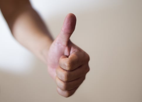 Close up of thumb up against white background. photo