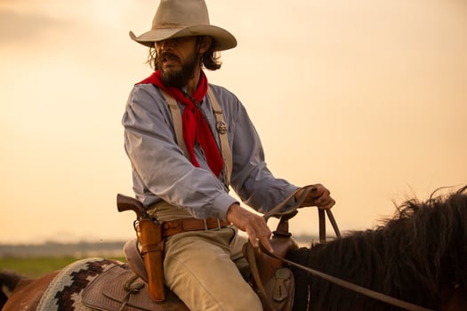 Cowboy on horseback against a beautiful sunset, cowboy and horse at first light, mountain, river and lifestyle with natural light background photo