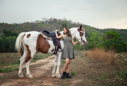 Young woman with her horse in evening sunset light. Outdoor photography with fashion model girl. Lifestyle mood photo