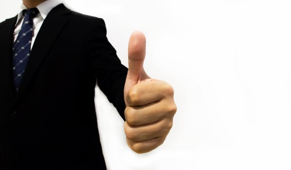 A man in a suit and tie giving the thumbs up photo