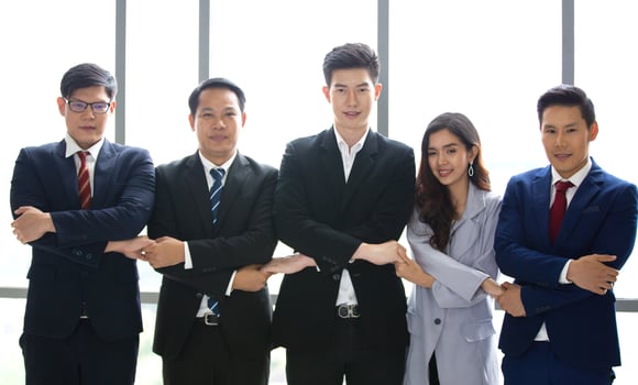 Successful business people standing together widen out showing strong relationship of worker community. A team of businessman and businesswoman expressing a strong group teamwork at the modern office. photo