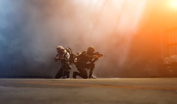 Silhouettes of army soldiers in the fog against a sunset, marines team in action, surrounded fire and smoke, shooting with assault rifle and machine gun, attacking enemy photo