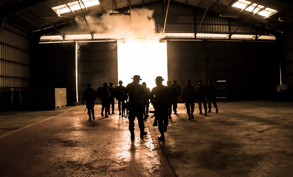 Silhouettes of army soldiers in the fog against a sunset, marines team in action, surrounded fire and smoke, shooting with assault rifle and machine gun, attacking enemy photo