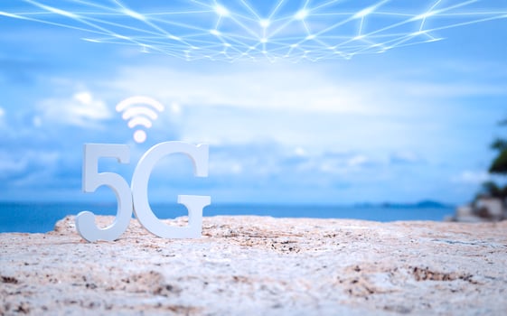 Symbol of white 5G with wifi and transmission network on stone seaside with blue sky. Network internet, communication wireless and 5G standard of signal social concept. photo