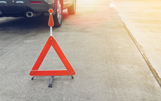 Broken car sign on a road with a broken down car photo
