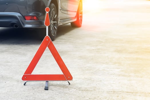 Broken car sign on a road with a broken down car photo