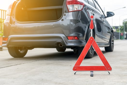 Broken car sign on a road with a broken down car photo