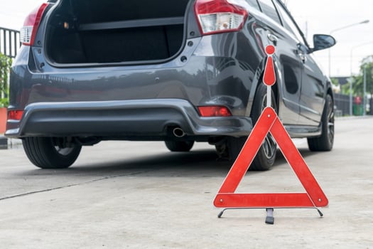Broken car sign on a road with a broken down car photo