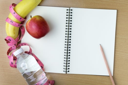 Healthy eating concept, tape measure, fruit and water bottle on a wooden background, blank copy space notebook photo