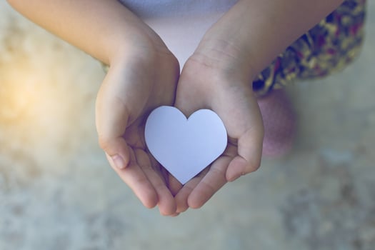 Children hands holding small model of heart and family , concept family photo