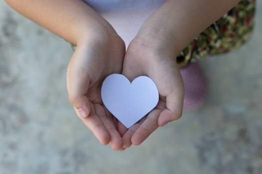 Children hands holding small model of heart and family , concept family photo