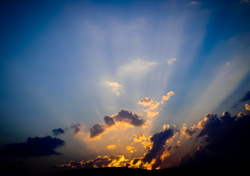 A ray of sunlight breaks through mountain and clouds in blue sky, growth of hope and the beginning. photo