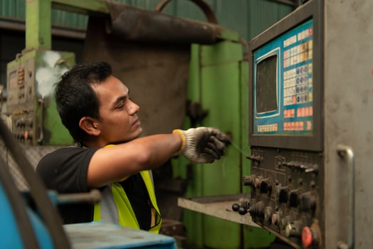 Asian mechanic working in a mechanical factory Repairing old machines photo