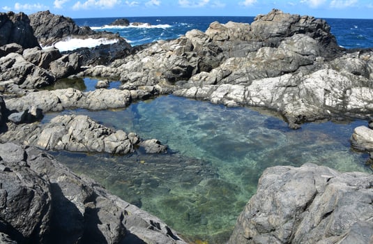 Serene Hidden Natural Pool Surrounded by Lava Rocks photo