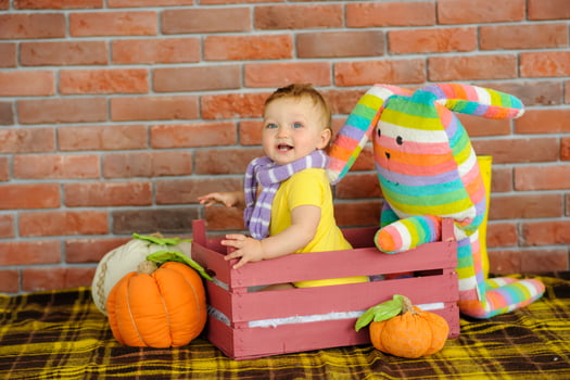 The little one-year-old girl smiles and sits. photo