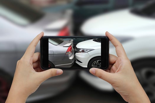Hand holding smart phone take a photo at The scene of a car crash, car accident.