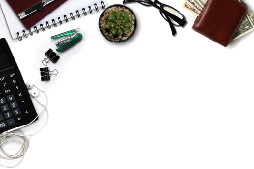 White office desk with calculator, wallet, and supplies. Top view with copy space photo