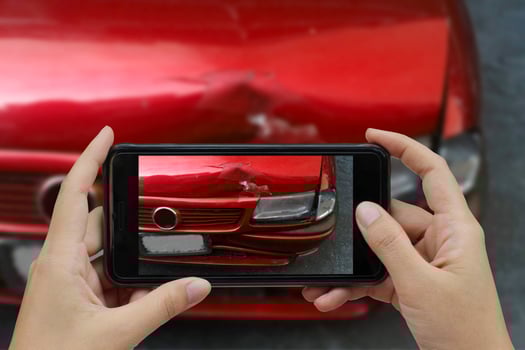 Hand holding smart phone take a photo at The scene of a car crash, car accident for insurance