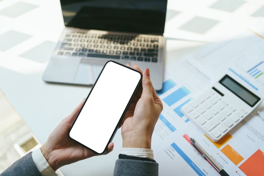 Mockup image of hands holding and using black mobile phone with blank desktop screen in office. clipping path. photo