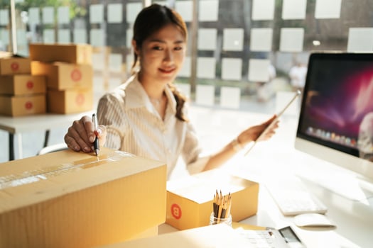 Portrait young attractive asia female owner startup business look at camera work happy with box at home prepare parcel delivery in sme supply chain, procurement, omnichannel commerce online concept. photo