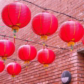 Beautiful round red lantern hanging on old traditional street, concept of Chinese lunar new year festival, close up. The undering word means blessing. photo