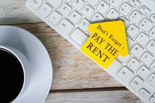 Don't forget, pay the rent text on yellow stick house shape on white keyboard. photo
