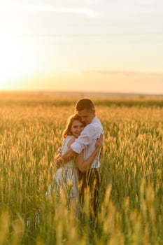 Bride and groom in a wheat field. The couple hugs during sunset photo
