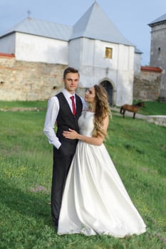 Bride and groom in a wheat field. The couple hugs during sunset photo