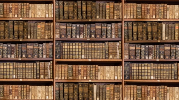 Defocused shelves of old antique books for background in video conference sized to 16 by 9 photo