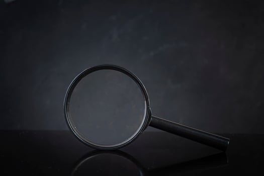 Search concept. Magnifying glass on dark background photo