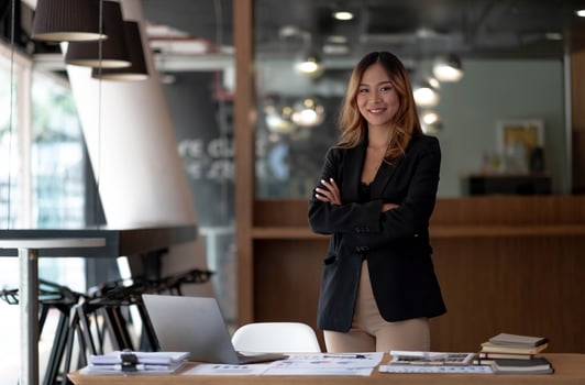 Image of a charming young Asian businesswoman standing at the office. Looking camera. photo